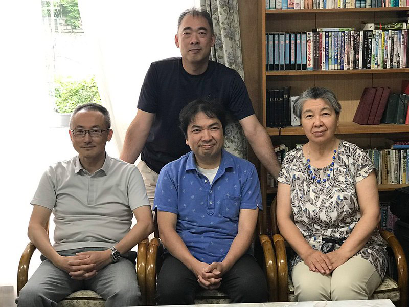 Group of four people sitting indoors.