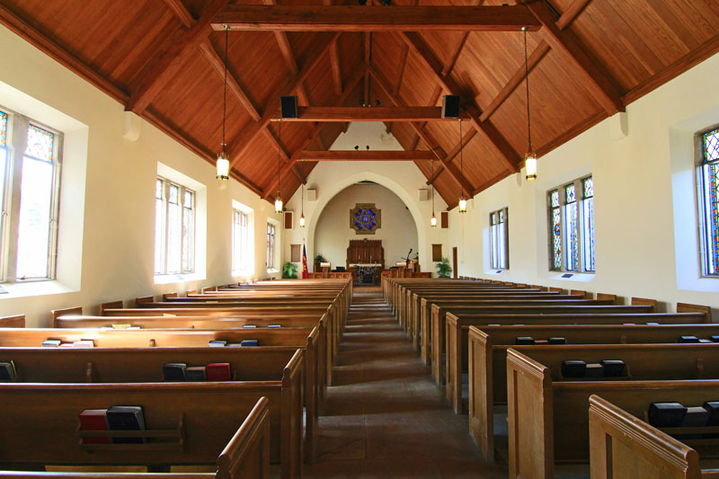 Empty church interior with wooden pews and ceiling.
