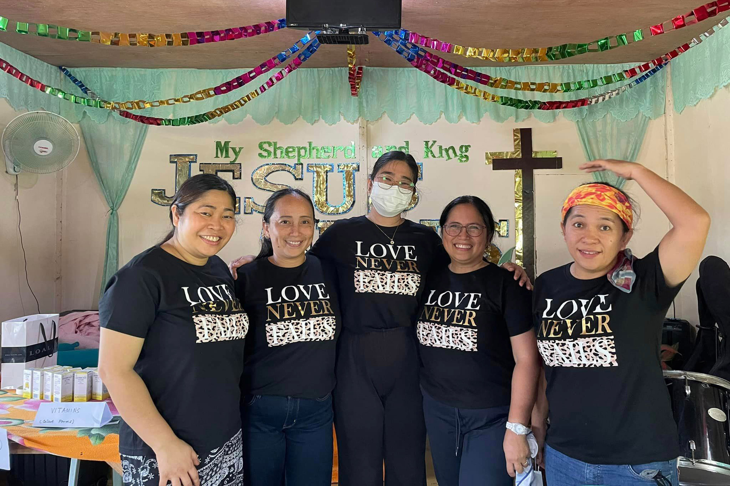 Group of women in matching shirts at church gathering.