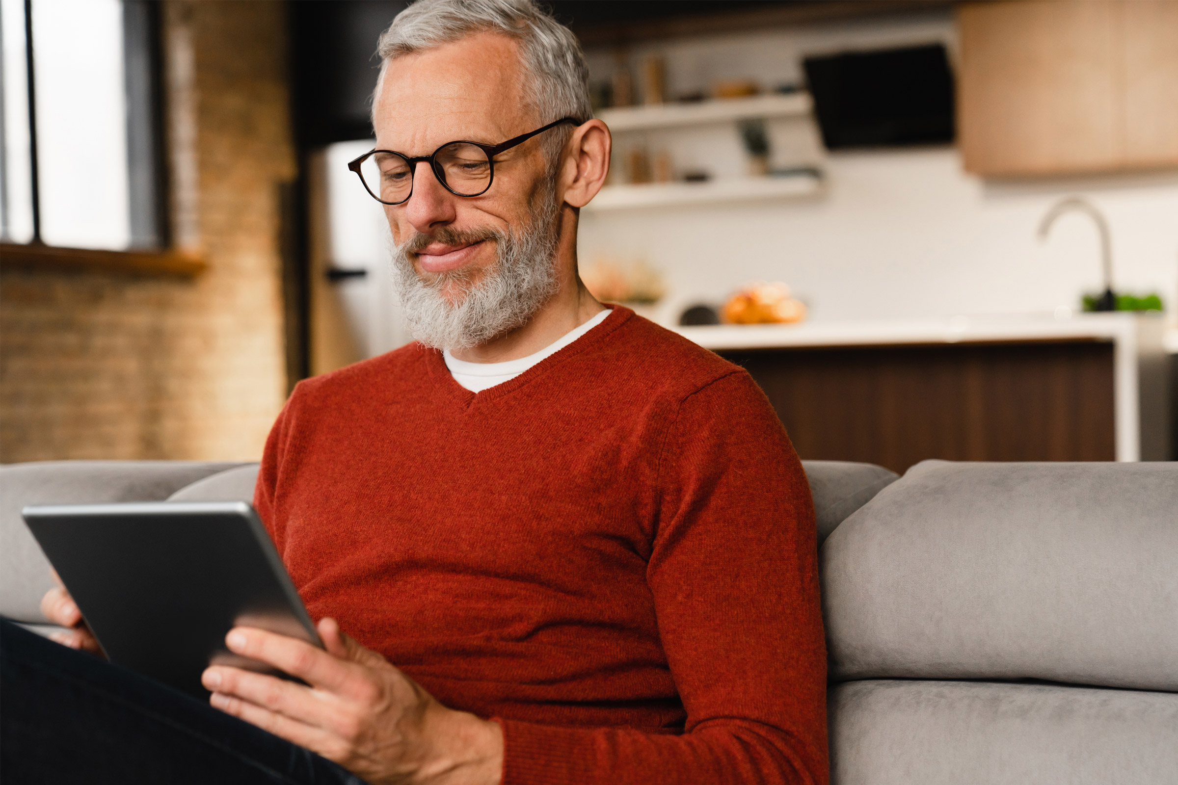 Man reading tablet on couch