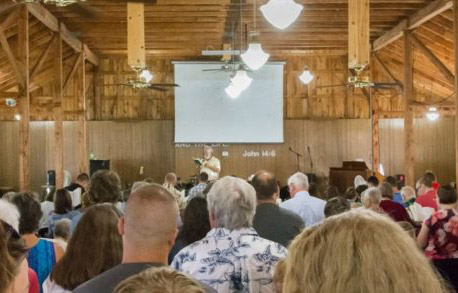 People gathered in a wooden church for a service.