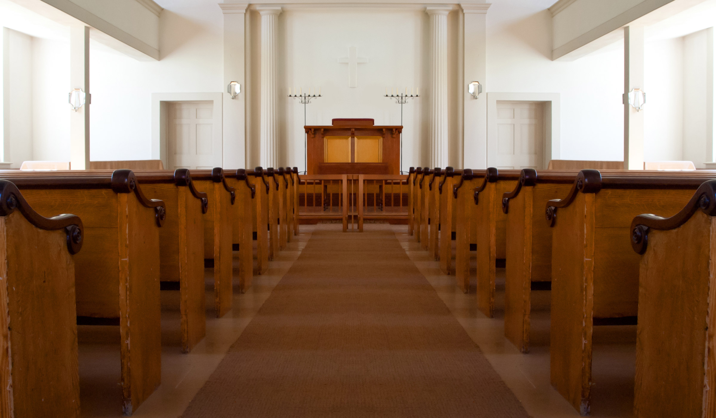 Empty church interior with wooden pews and altar.