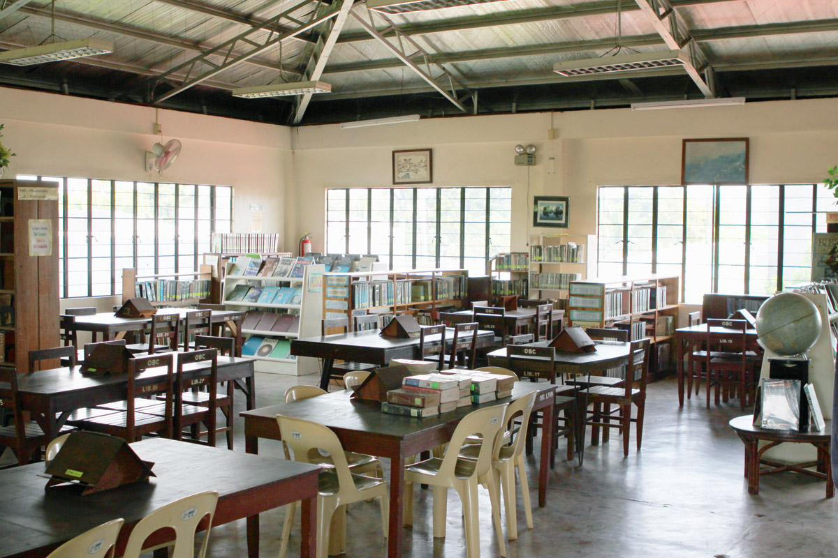 Sunny library with tables and bookshelves