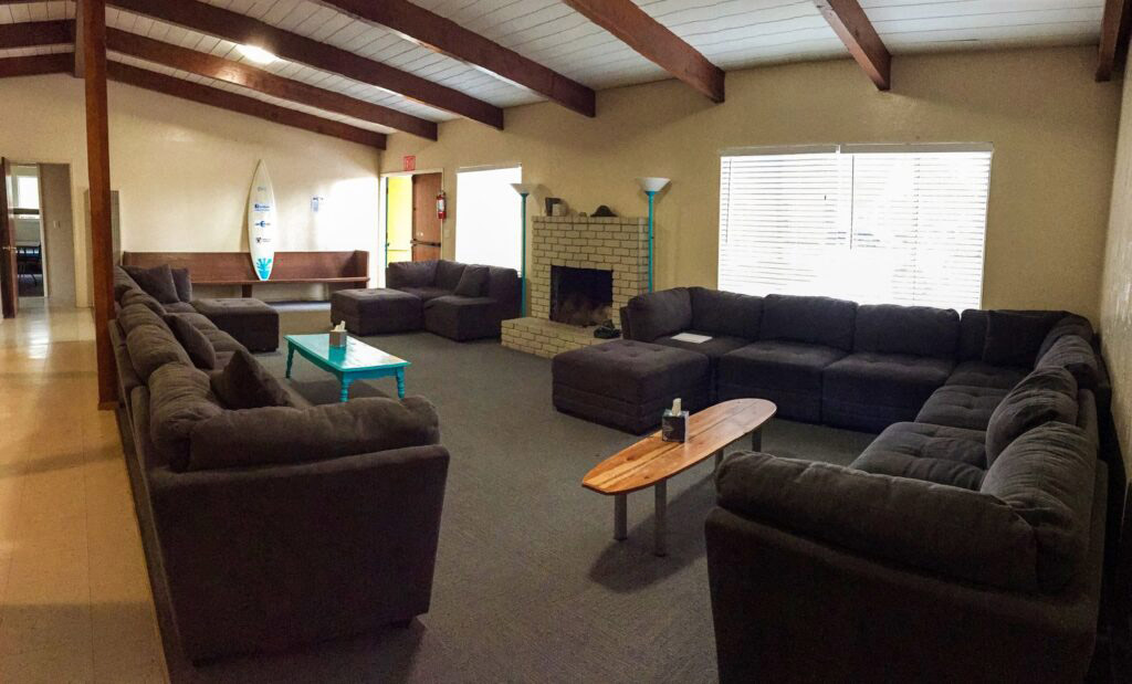 Cozy room with sofas and surfboard decor.